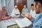 recitation leader called kyai reading the holy Quran at home
