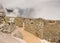 Reconstructed walls of Machu Picchu citadel surrounded by fog, in Urubamba, Peru