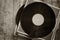 Records stack with record on top over wooden table. vintage filtered