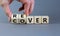 Recover symbol. Concept word `recover` on wooden cubes on a beautiful grey table. Businessman hand. Grey background. Business an