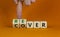 Recover symbol. Concept word `recover` on wooden cubes on a beautiful orange table. Businessman hand. Orange background. Busines