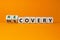 Recovery or discovery symbol. Turned a wooden cube, changed a word `discovery` to `recovery`. Beautiful orange background.