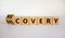 Recovery or discovery symbol. Turned a wooden cube, changed a word `discovery` to `recovery`. Beautiful white background. Busi