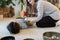 Recovery massage with tibetan singing bowls. Female at asian sound therapy with bronze bowls gong