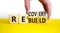 Recovery and rebuild symbol. Businessman turns cubes and changes the word `recovery` to `rebuild`. Beautiful yellow table, whi