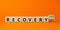 Recovery symbol. Turned a wooden cube and changed words `recovery no` to `recovery yes`. Beautiful orange background. Business