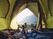 Recreation at mountain in camping tent.group of feet lying down inside tent with mountain view in sunset with friend