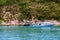 Recreational boats anchoring near small islands. A group of unrecognizable people having fun activities on holidays vacation.