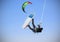 Recreational water sports: kitesurfing. Kiteboarding sportsman jumping high in the sky on windy day. Extreme sports action