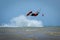 Recreational water sports: kitesurfing. Kiteboarding sportsman jumping high in the sky on windy day. Extreme sports action