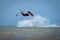 Recreational water sports: kitesurfing. Kiteboarding sportsman jumping high in the sky on windy day. Extreme sports action