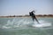 Recreational water sports: kitesurfing. Kiteboarding sportsman jumping high in the sky on windy day. Extreme sports action