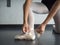 Recreational young female ballet dancer ballerina, in the studio putting on her pointe shoes, tying up