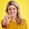 Recruitment, happy and portrait of a woman pointing finger isolated on a yellow background in a studio. Smile, hiring