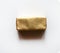 Rectangle chocolate candy wrapped in golden foil  on white surface