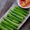 Rectangle plate boiled okra with fermented tofu on wooden background