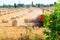 Rectangular baler discharges straw bale in a field during the harvesting process