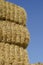 Rectangular bales of dry hay against the blue sky