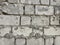 Rectangular brick wall with gray cement between the stones