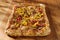 Rectangular gourmet pizza with sausage and colorfu