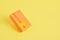 Rectangular orange flying gift box with bow on yellow background