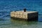 Rectangular pier with old dark cast iron column built do dock small boats in shallow water. Location northern Dalmatia, Croatia.