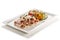 Rectangular plate with veal with tuna sauce chives caper flowers and grilled vegetables