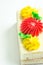 Rectangular Slice of Sponge Layer Cake with Whipped Butter Cream Frosting. Decorated with Red Yellow Daisy Flowers