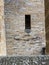 A rectangular window on a stone wall of Hohenzollern castle with a metal bars grid on it