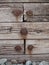 Rectangular wooden planks fastened with rusty large nails and pebbles on the ground