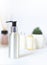 Recyclable metallic cosmetic face cleanser bottle with pump in the bathroom. Body wash concept