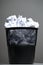 Recycle bin filled with crumpled papers