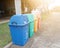 Recycle bins, yellow, green, blue and red, with recycling symbols placed on the outdoor pathway floor