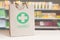 Recycled paper bag with a green Pharmacy logo in a drugstore. Empty copy space