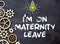 Recycled paper note pinned on cork board.I'm on Maternity Leave Message