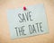 Recycled paper note pinned on cork board.Save the Date Message