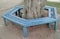 Recycled plastic used to manufacture new park bench around tree