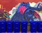 Recycling blue bins lined up against colorful wall mural of big blue creature