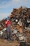 Recycling industry, worker using phone and heap of old metal