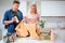 Recycling. Responsible young couple putting empty plastic and paper in garbage bags while standing near the table filled