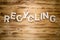 RECYCLING word made with building blocks on wooden board