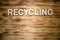 RECYCLING word made with building blocks on wooden board