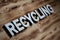 RECYCLING word made with building blocks on wooden board