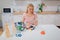 Recycling. Young smiling woman is sorting emty plastic bottle and lids while sitting at the table