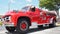 Red 1956 Ford F800 Big Job firefighter truck shines under the sun at vintage auto show in