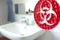 Red 3D printed sculpture with biohazard symbol in front of a bright bathroom sink at home