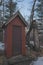 Red abandoned outhouse in the woods under the moon and moonlight at dusk with a fallen tree - taken near the Governor Knowles Stat