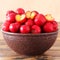 Red acerola (malpighia glabra), tropical fruit in brown bowl