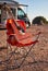 Red acoustic guitar on a folding chair near camper