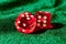 Red acrylic transparent dices for games. Two gambling translucent dices on green velvet surface, close-up